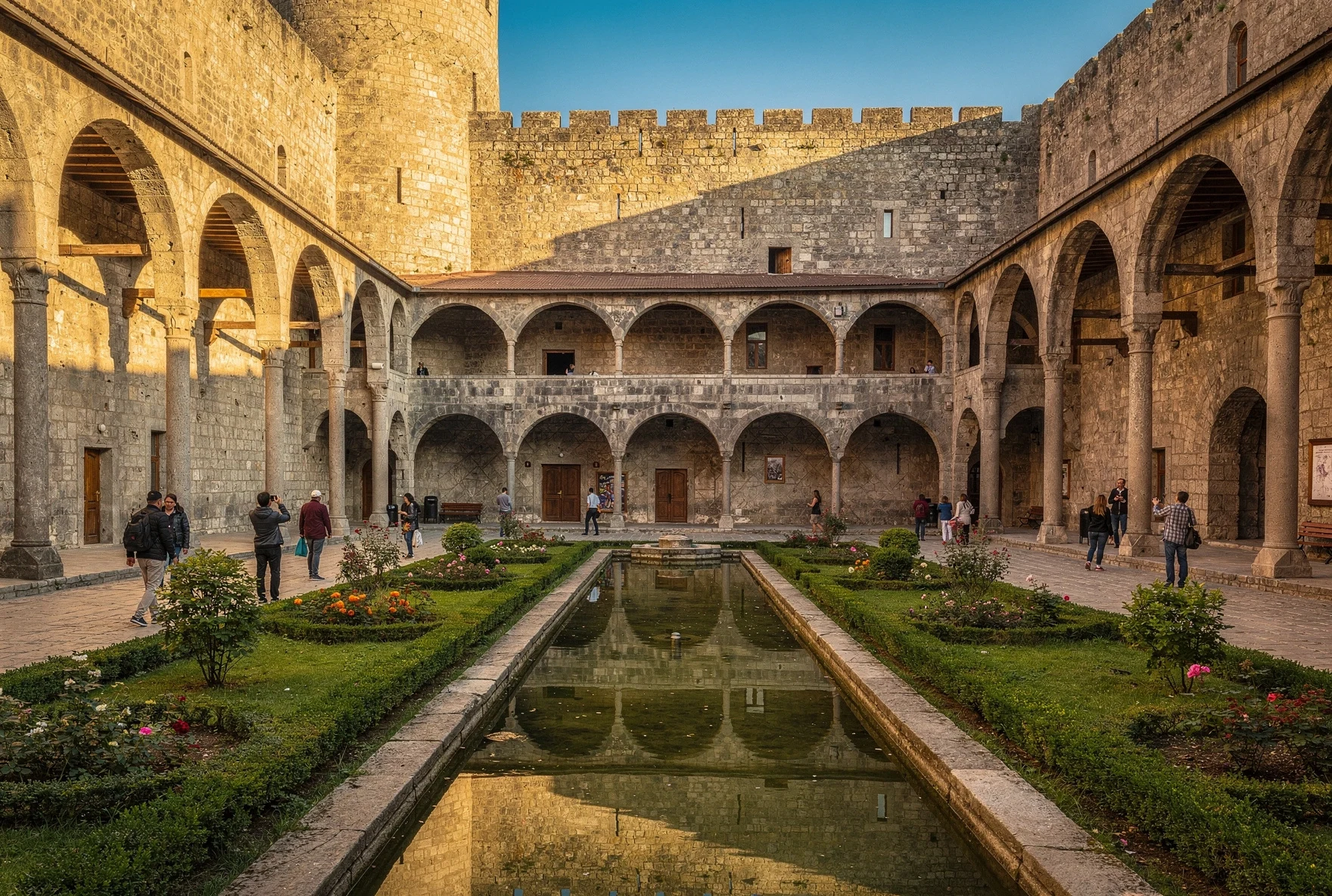 Interior courtyard of Rabati Fortress with arched stone walkways, manicured gardens, and a reflecting pool