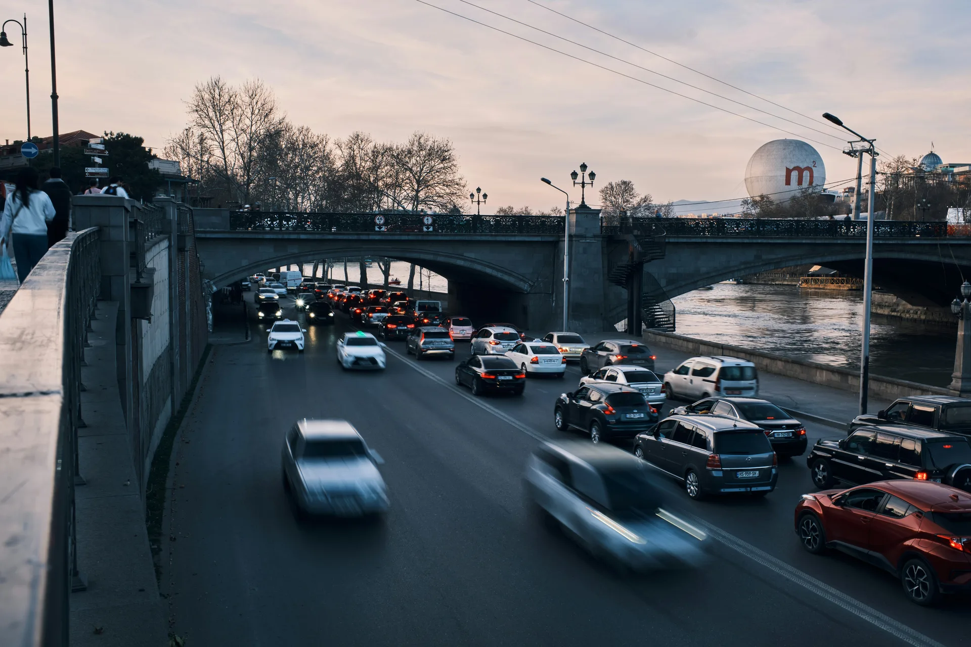 Heavy traffic flowing along the Kura River in central Tbilisi at dusk