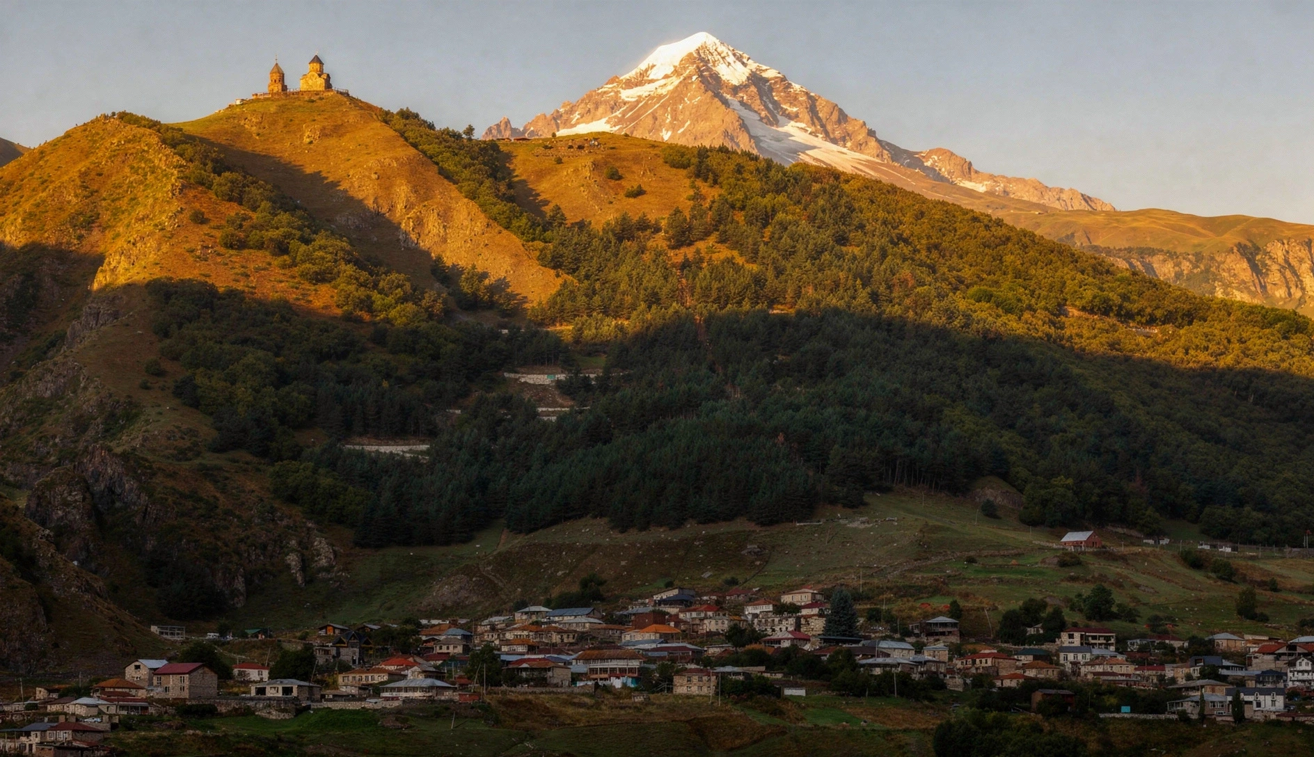 Gergeti Trinity Church perched on a hilltop with the Caucasus mountains rising behind it