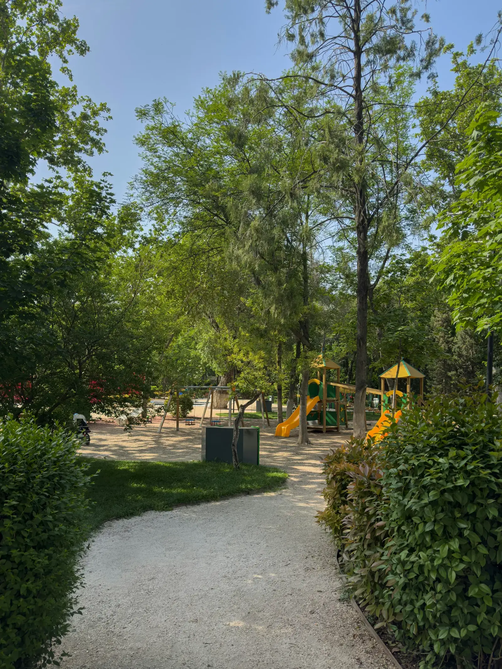 A lush green park in Kutaisi with tree-lined paths and playgrounds