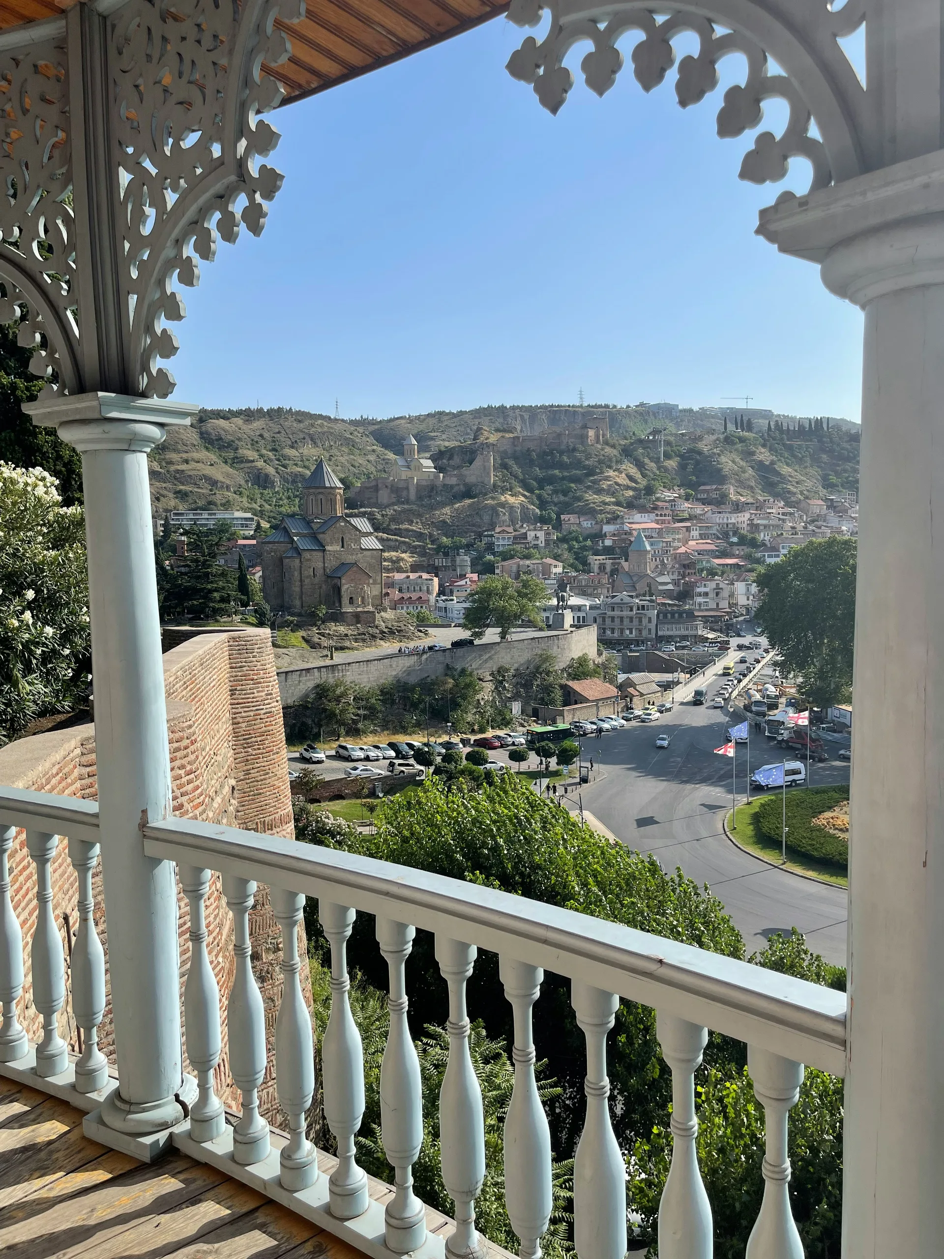 View from a traditional Tbilisi wooden balcony overlooking the city and Metekhi Church