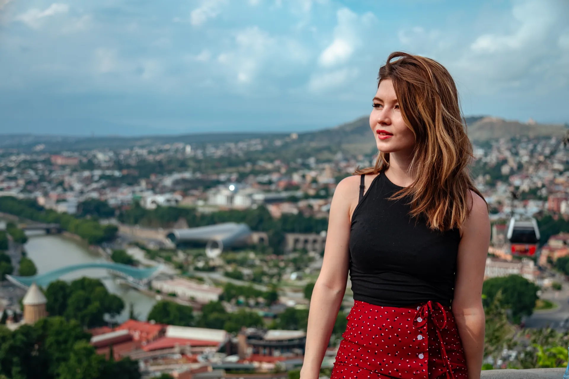 A solo female traveler enjoying a panoramic view over Tbilisi