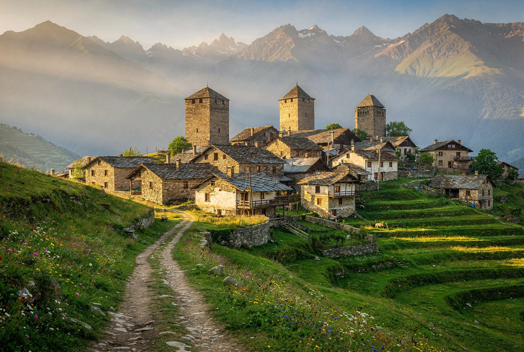 Traditional stone village with defensive towers in Georgian highlands during summer golden hour