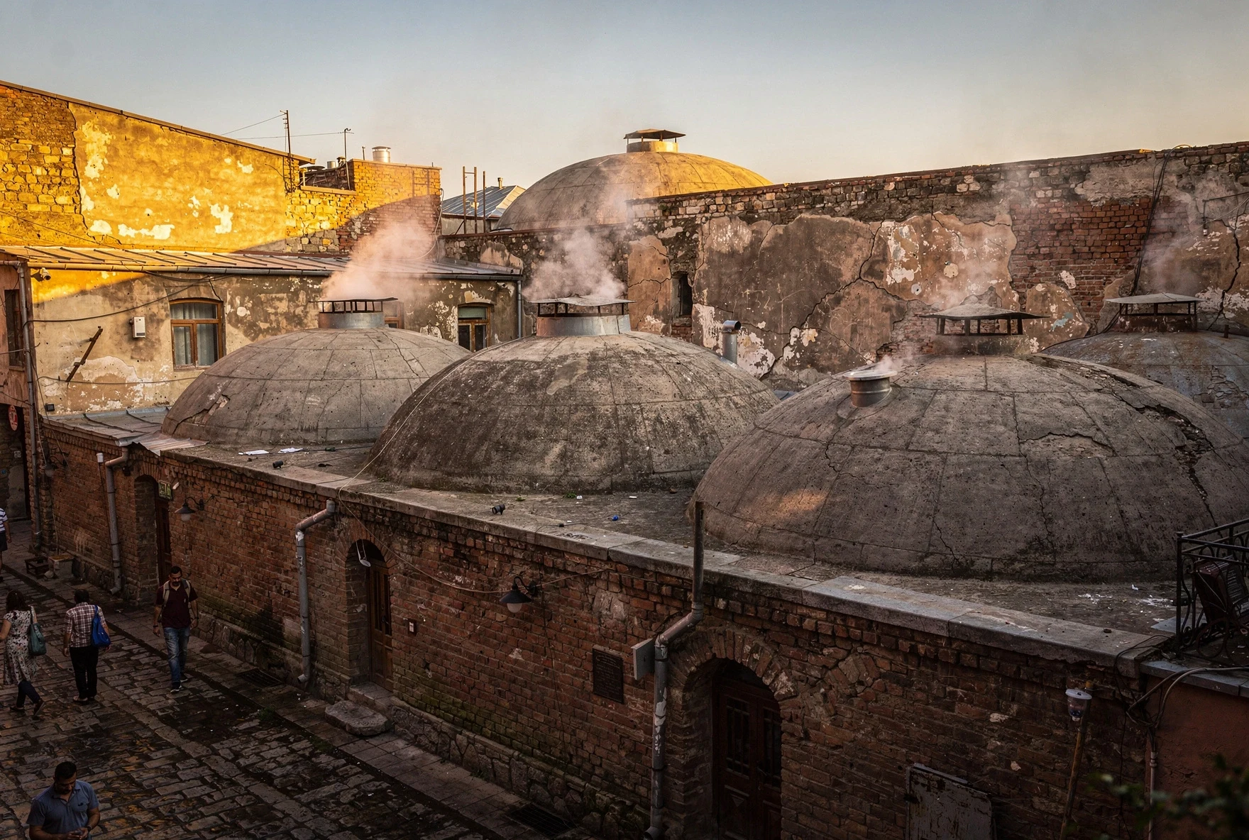 Abanotubani sulfur baths district with brick domed rooftops and steam rising in golden afternoon light
