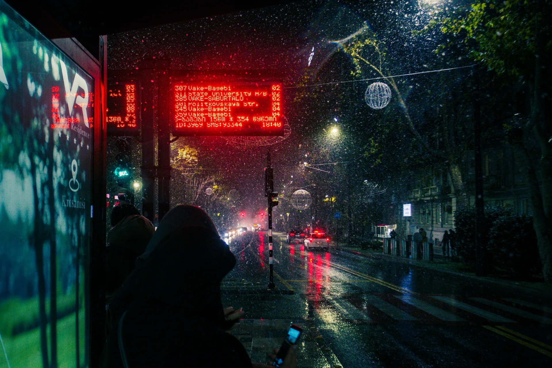 Tbilisi bus stop at night showing electronic route display board